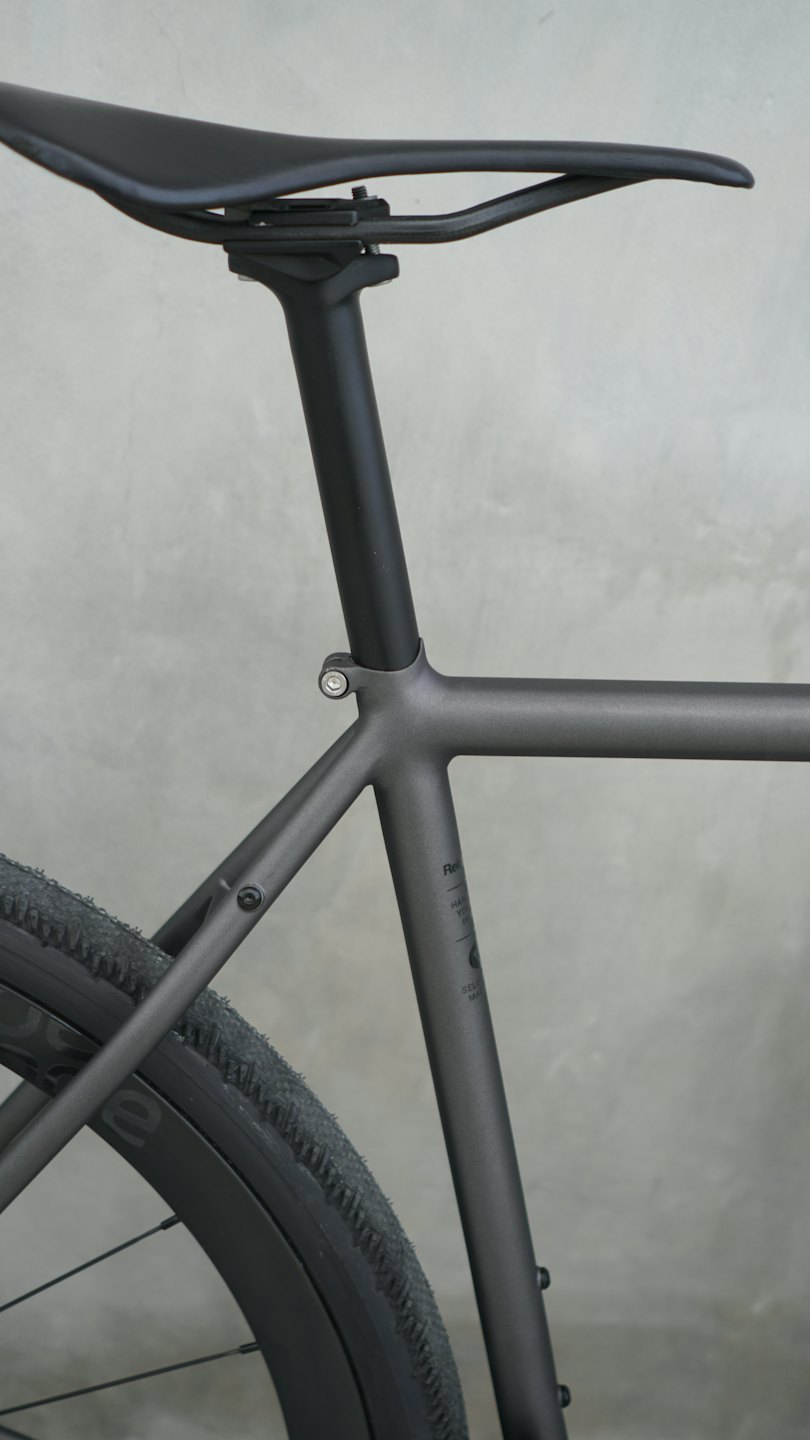Sezione posteriore di una moderna bicicletta da ghiaia parcheggiata contro il cemento.