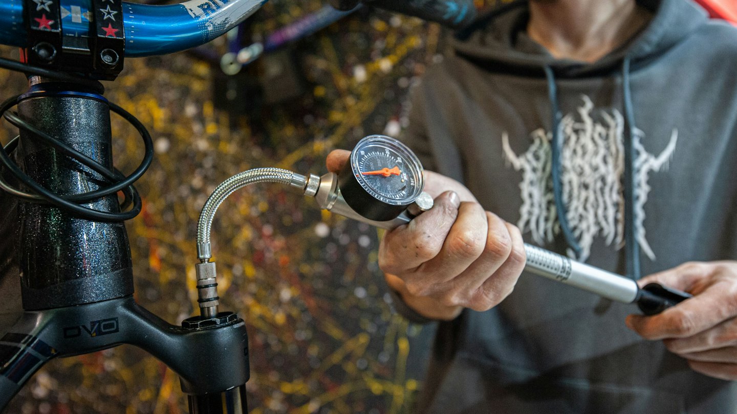 Persona che gonfia una forcella ammortizzata per bicicletta con una pompa per ammortizzatori.