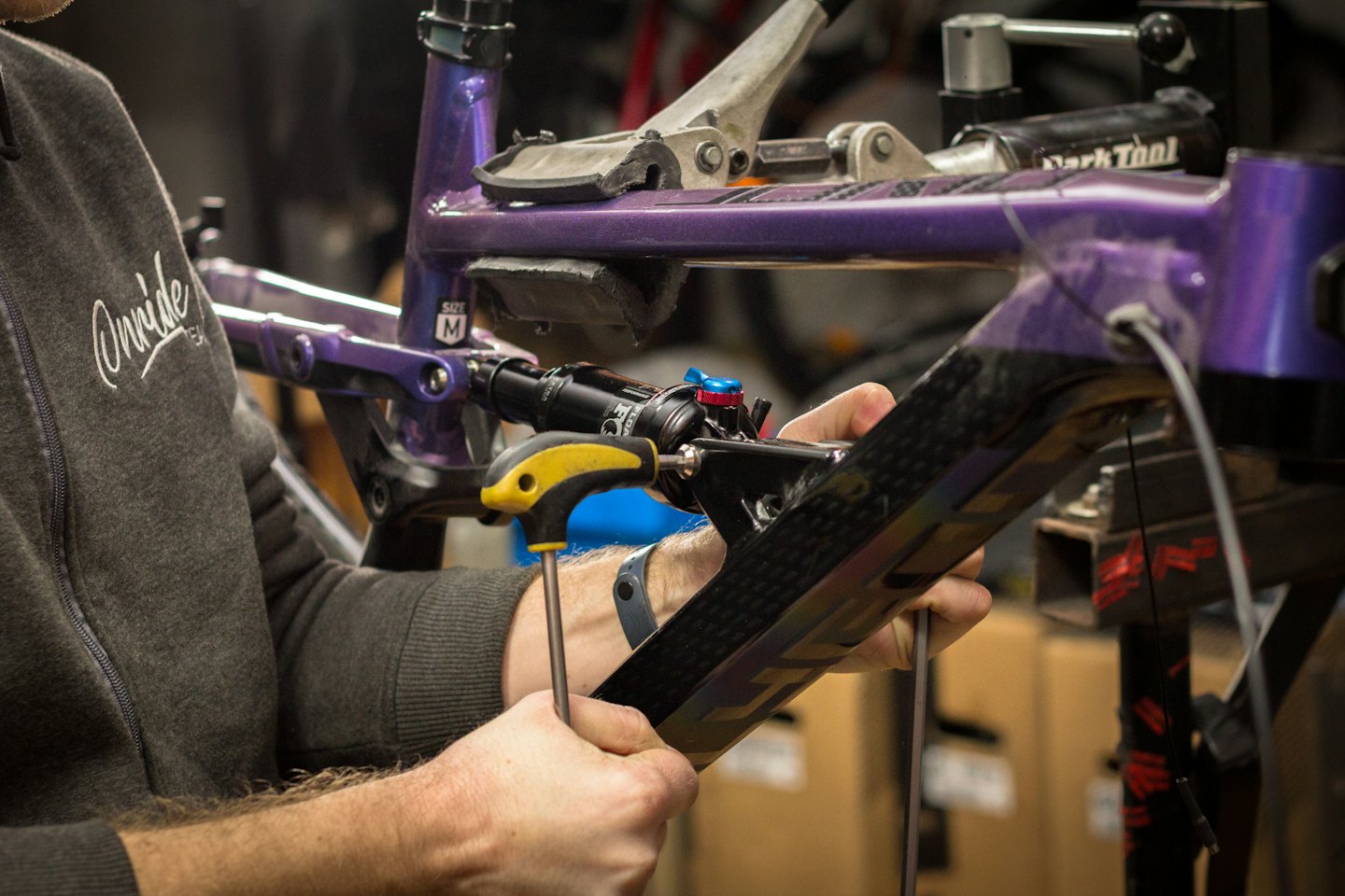 Un tecnico usa una chiave a brugola per assemblare il telaio di una bicicletta.